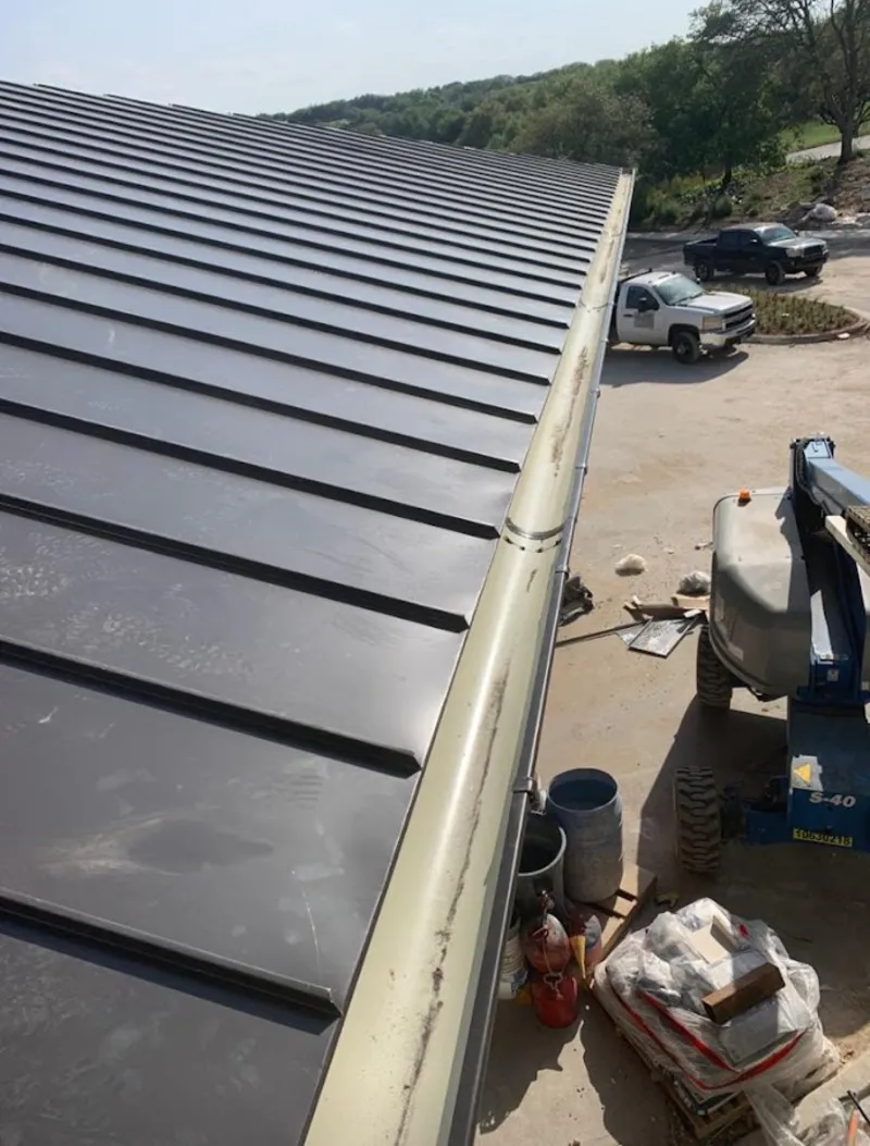 Standing seam panel and gutter detail on a metal roofing jobsite in Concord